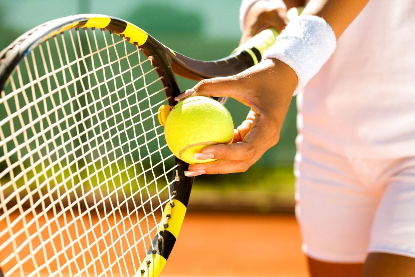 Close up of tennis rocket with ball in hand