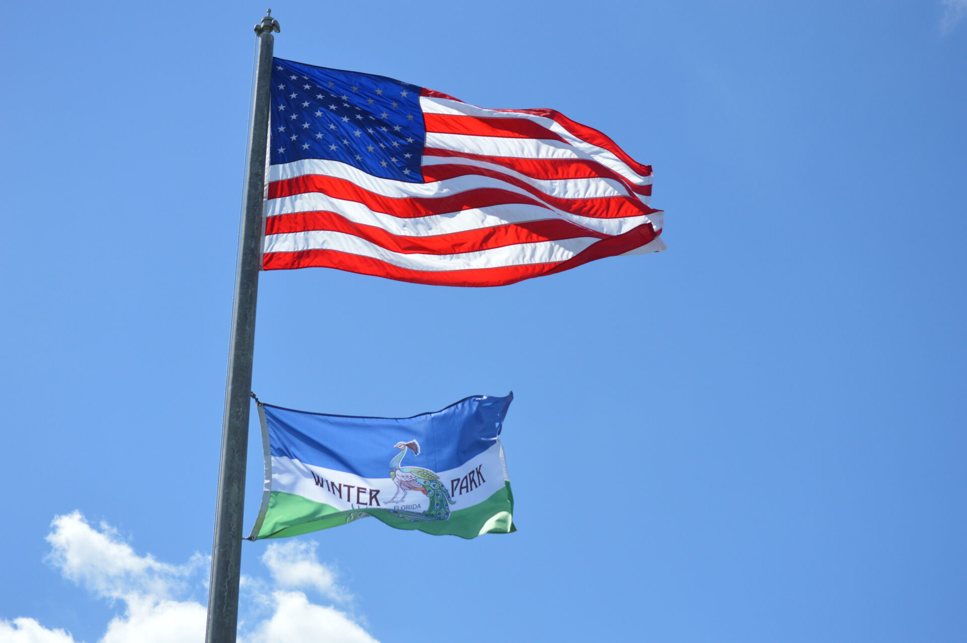 American and Winter Park flags against sky.